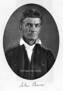 John Brown c. 1856. Image courtesy of West Virginia State Archives. Head and shoulders portrait. Brown is clean shaven with short hair, is wearing dark jacket and vest, and a white collared shirt.